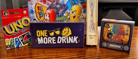 A table with various board games including UNO, Race to Base, and Crazy Pickle.