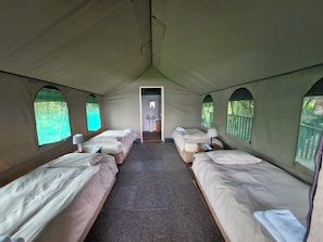 Cozy accommodations feature four beds, a small table, and a sink, perfect for a comfortable stay.