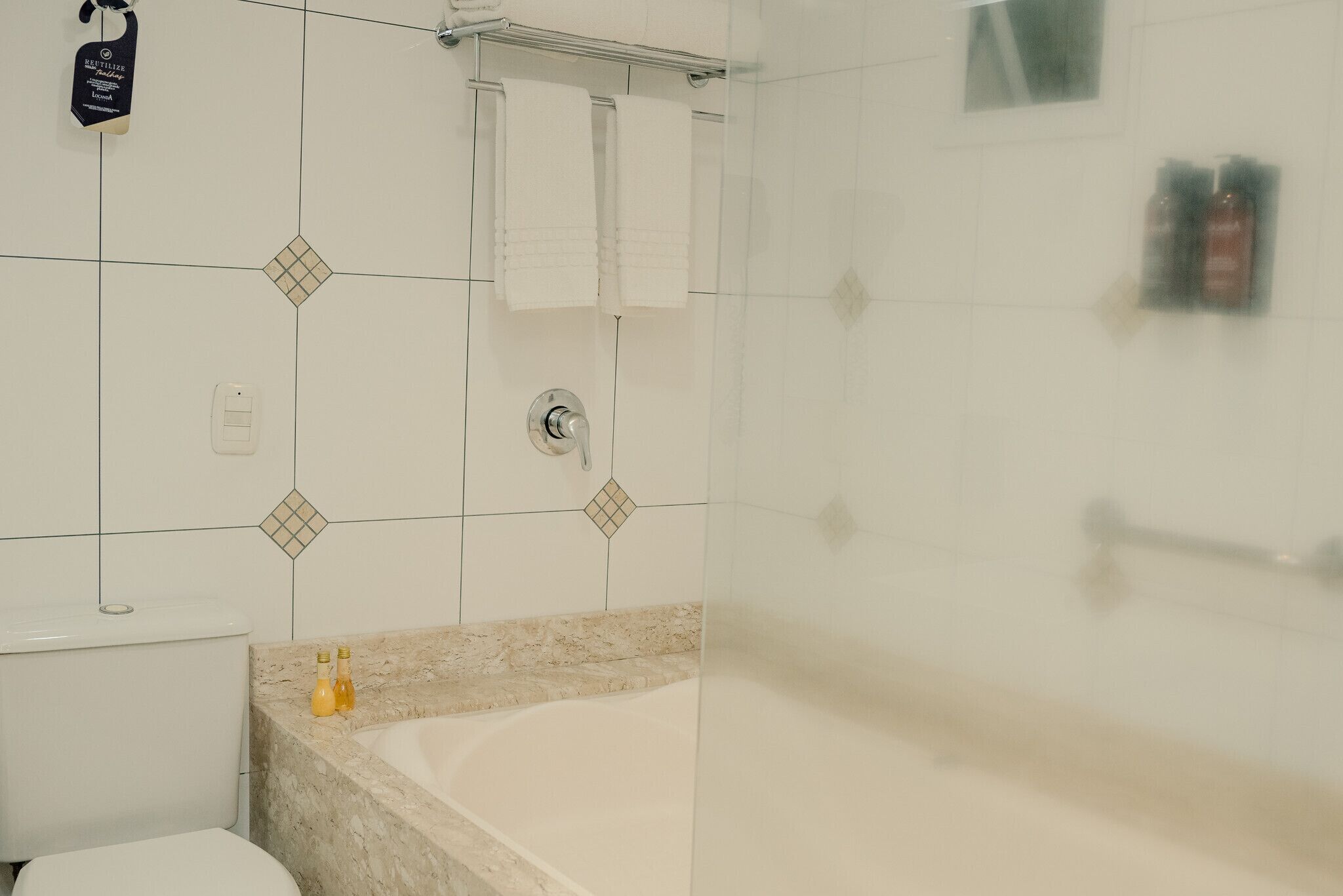 A bathroom with a toilet, a bathtub, and a shower area.