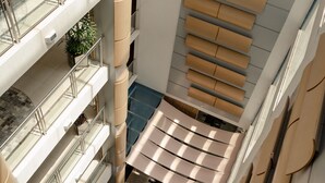 A multi-level interior with glass railings, a checkered floor pattern, and a series of beige panels on the walls. - Locanda Hotel (Novo Hamburgo)