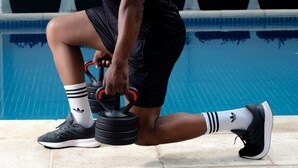A person performing a leg exercise by the poolside. - Locanda Hotel (Novo Hamburgo)