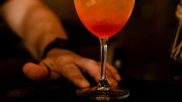 On est en train de décorer un cocktail avec une tranche de citron.