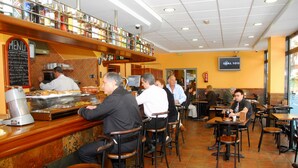 Un restaurante con mostrador, taburetes y mesas.