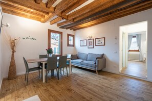 Relax in this inviting space with a dining area, sofa, and large window offering a view of the outside.