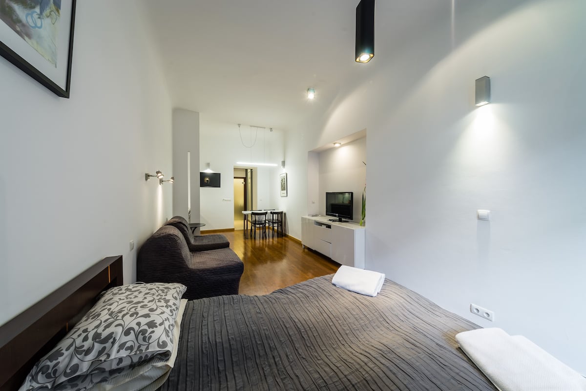 Une chambre d’hôtel moderne équipée d’un grand lit, d’un canapé, d’un bureau et d’une télévision.