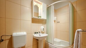Une salle de bain avec des toilettes, un lavabo et une douche.