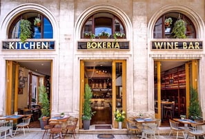 A building with three storefronts labeled 'KITCHEN,' 'BOKERIA,' and 'WINE BAR.' - Villa Olea (Split)