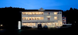 Un edificio de varios pisos con letreros que indican que es un hotel y restaurante.