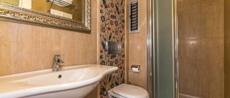 A bathroom with a sink, toilet, and shower.