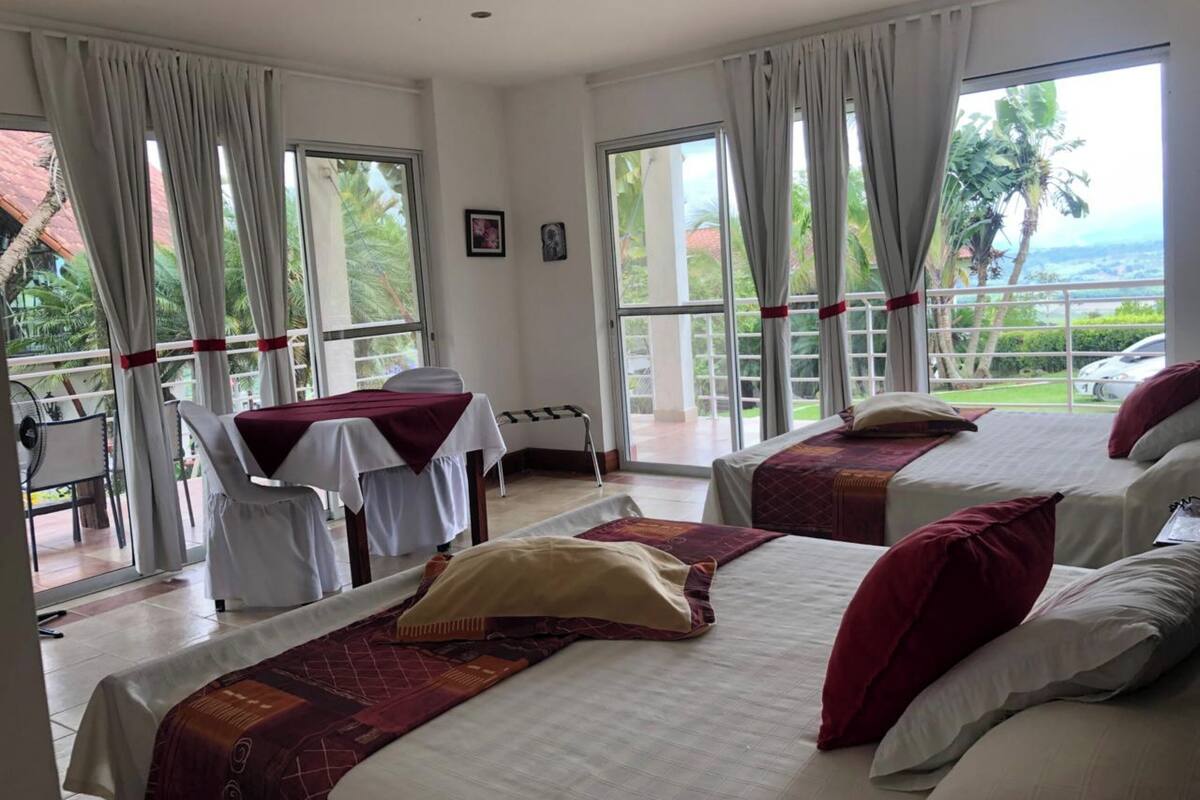 Habitación de hotel con dos camas, una mesa y una silla.