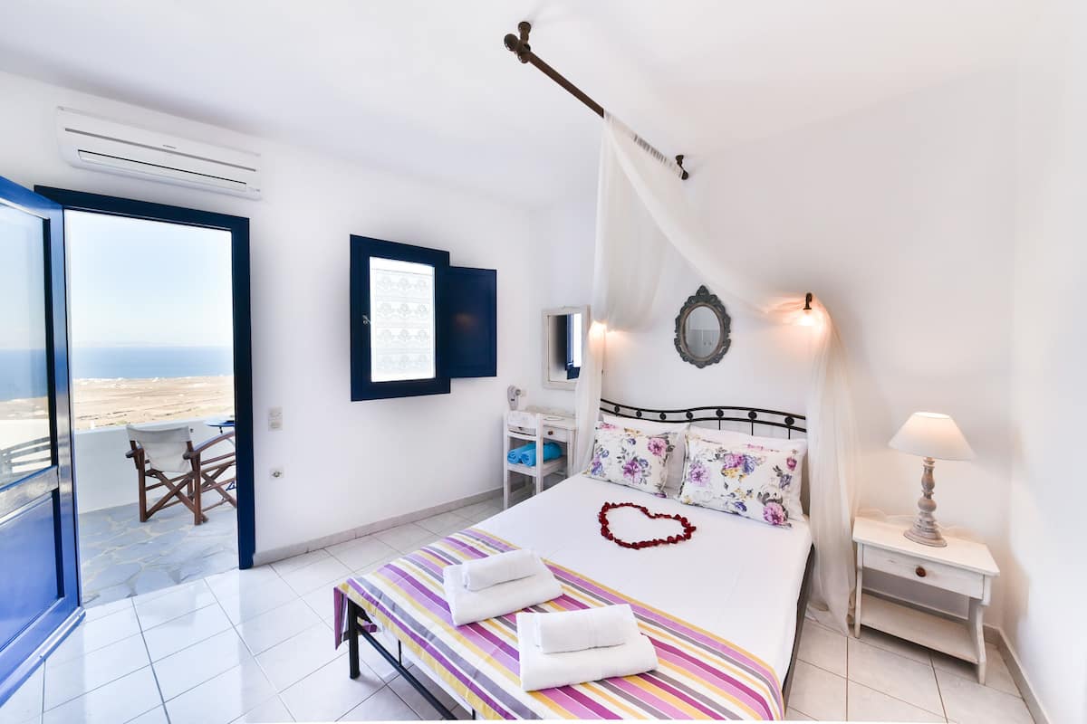 Ein Schlafzimmer mit Bett, Nachttisch und Meerblick.