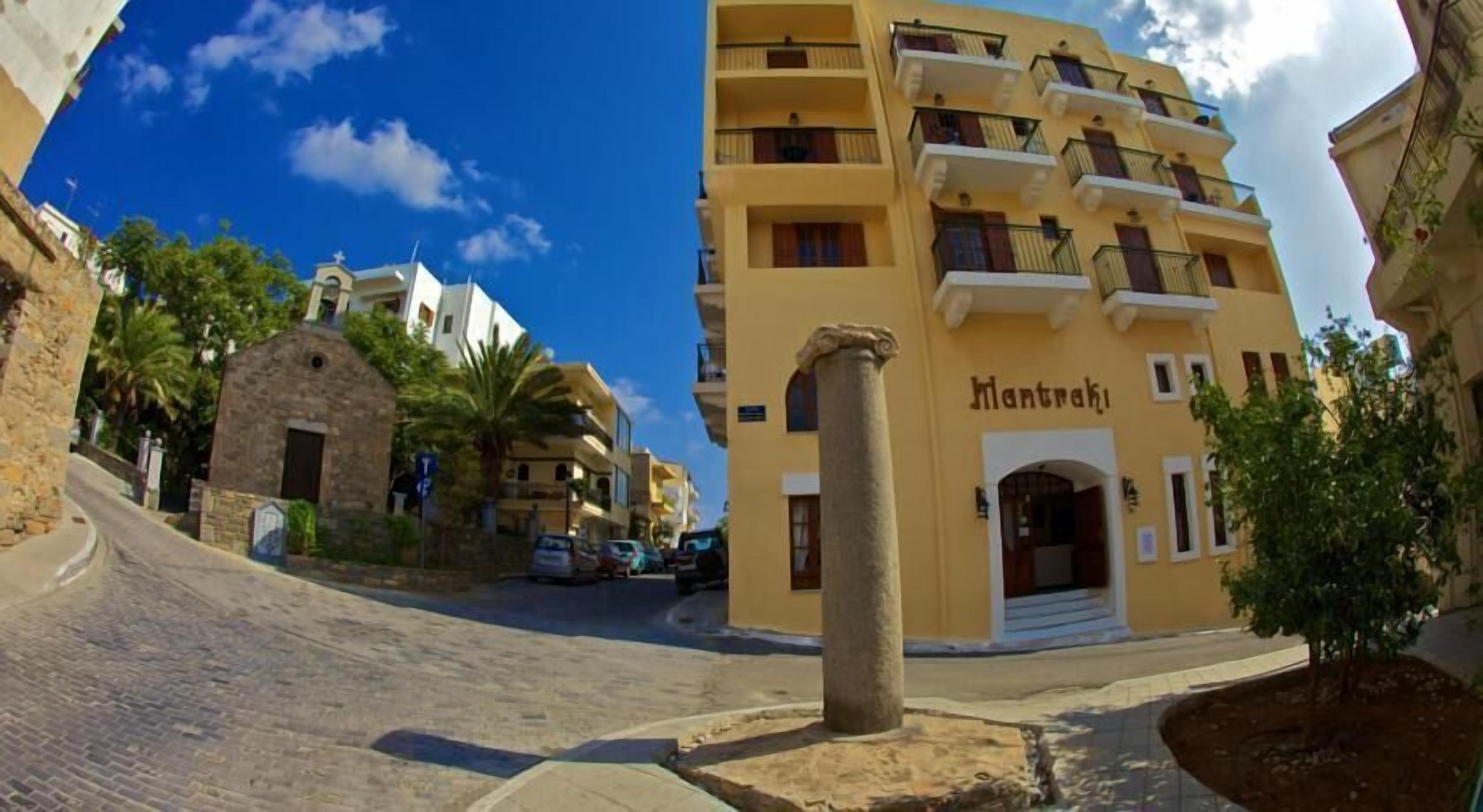 A yellow building with balconies and a stone archway.