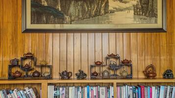 A bookshelf with a framed painting above it.