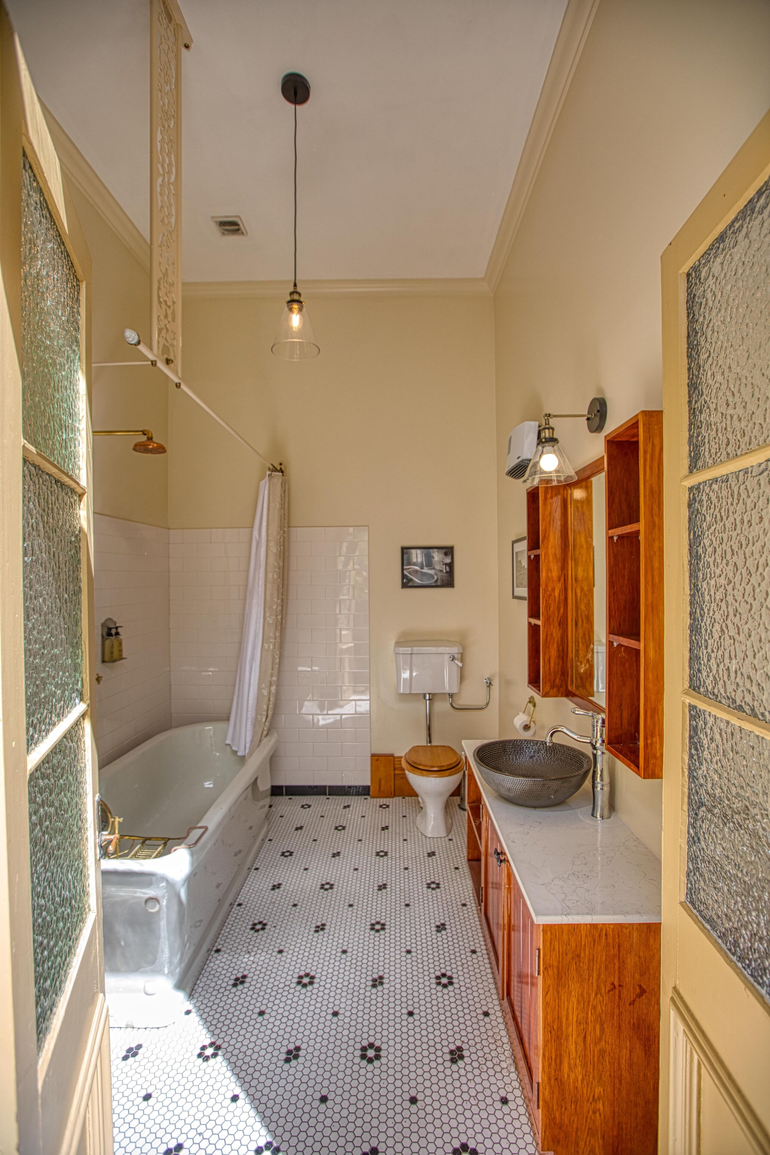 A bathroom with a bathtub, toilet, sink, and a mirror.