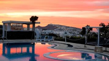 Relax by the serene pool surrounded by a glass-enclosed structure and lounge chairs.