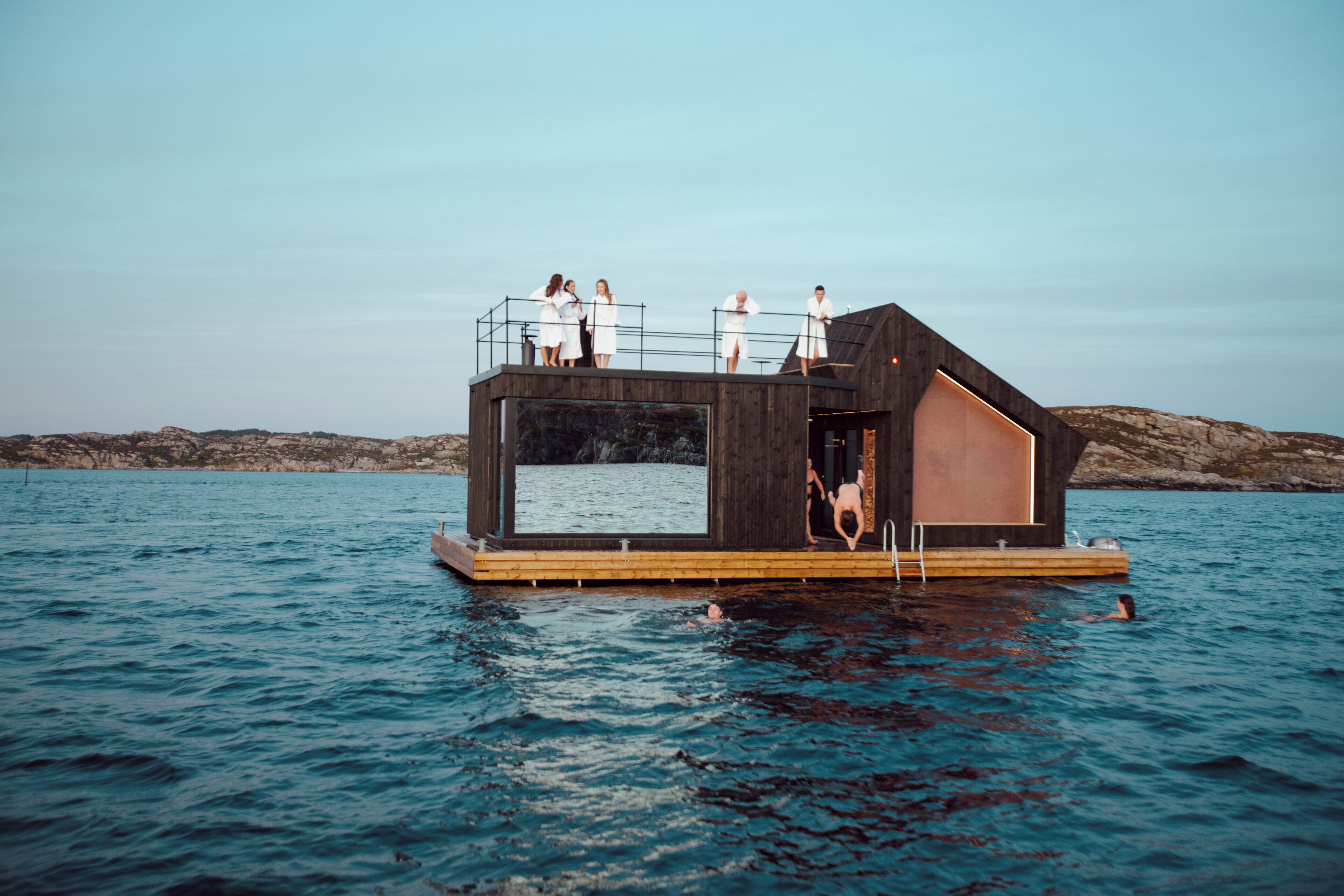 Une structure flottante en bois, dotée d’une grande fenêtre et d’une petite terrasse.