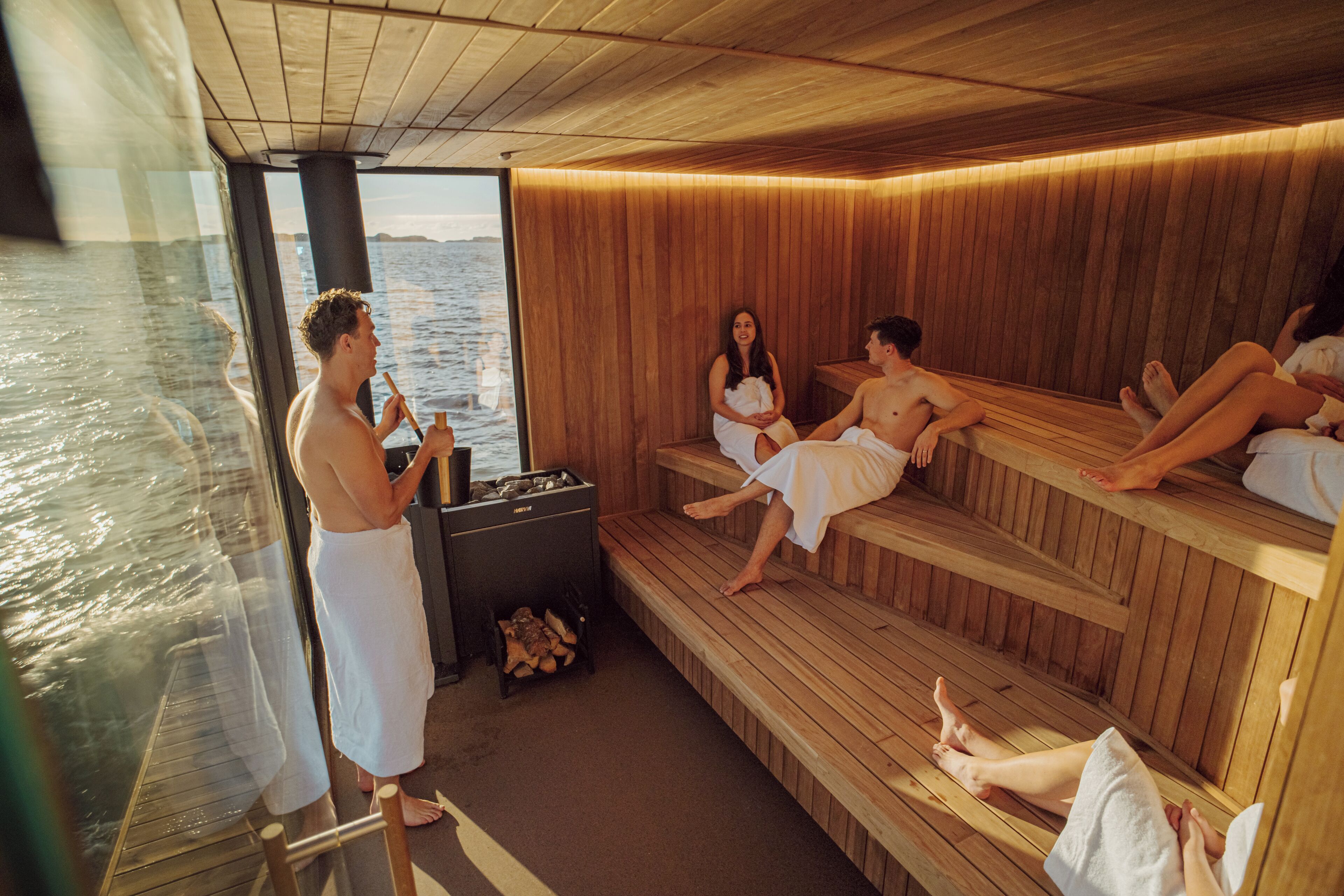 A sauna with wooden benches and a view of the water.