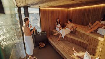 A sauna with wooden benches and a view of the water.