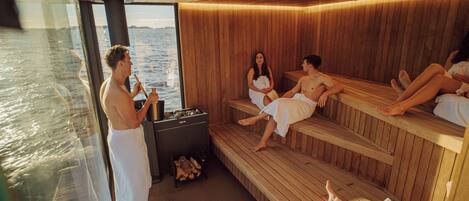 A sauna with wooden benches and a view of the water.