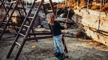 Children can play on the outdoor swing set with swings suspended from a sturdy frame.