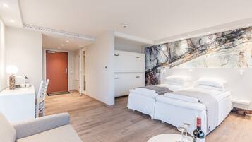 Una habitación de hotel moderna con cama, escritorio y zona de comedor.