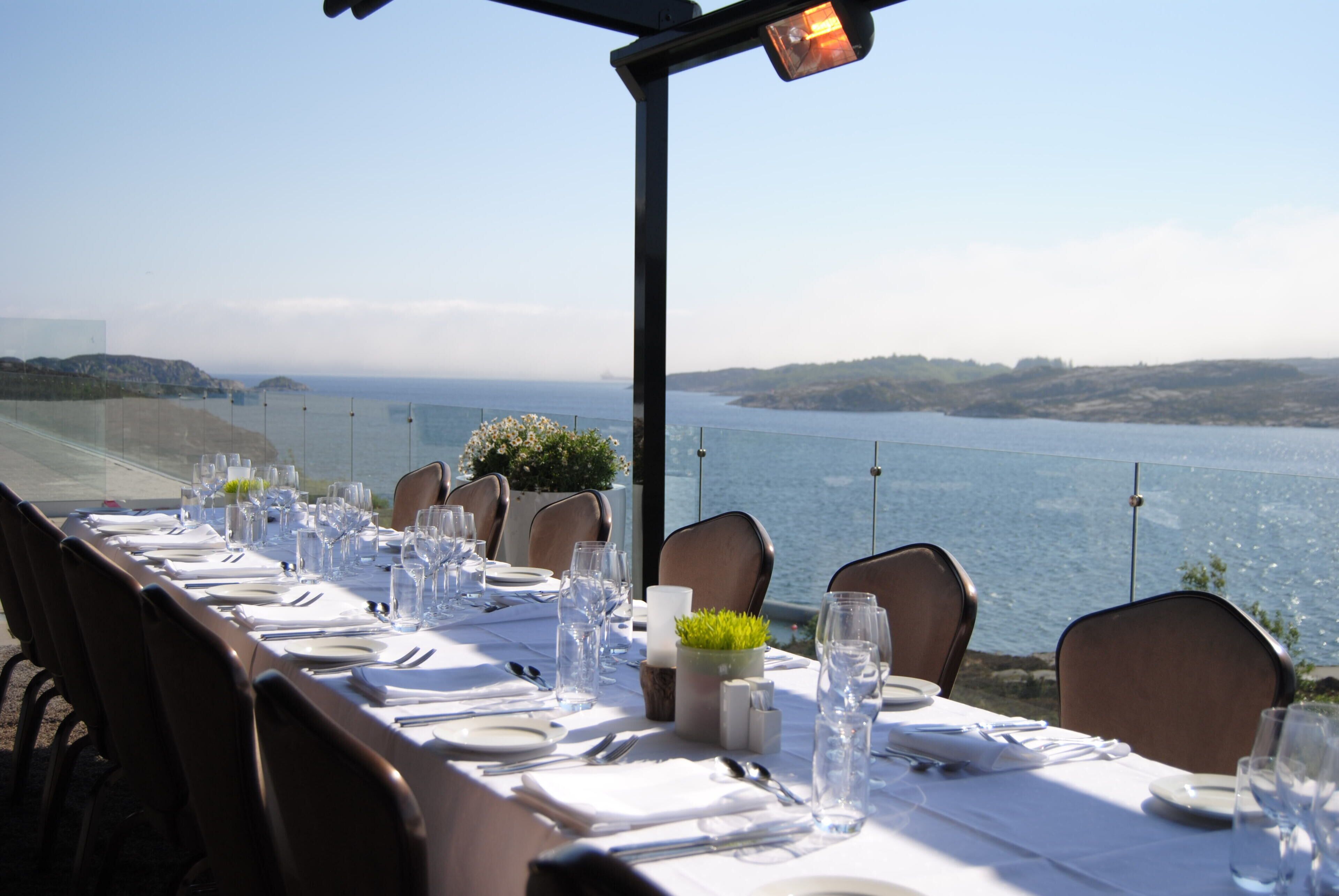 A table set for a meal with a view of the sea.
