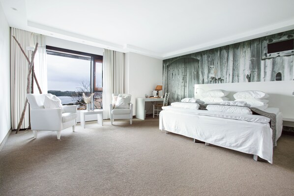 A modern hotel room with a large bed, a desk, and a view of the outdoors. - Panorama Hotell & Resort (Oygarden)