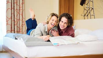 Een bed met een kaart, een houten hoofdbord en een gordijn met een patroon.