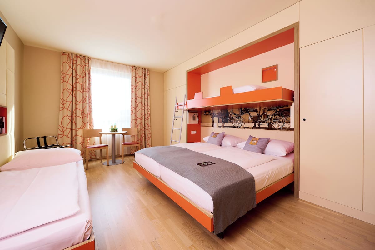 Een slaapkamer met een stapelbed, een bureau en een stoel.