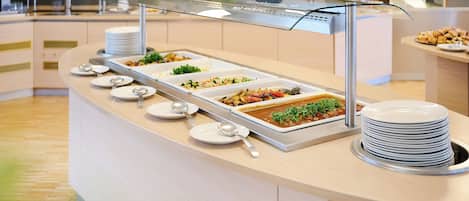 A buffet setup with various food items and utensils.
