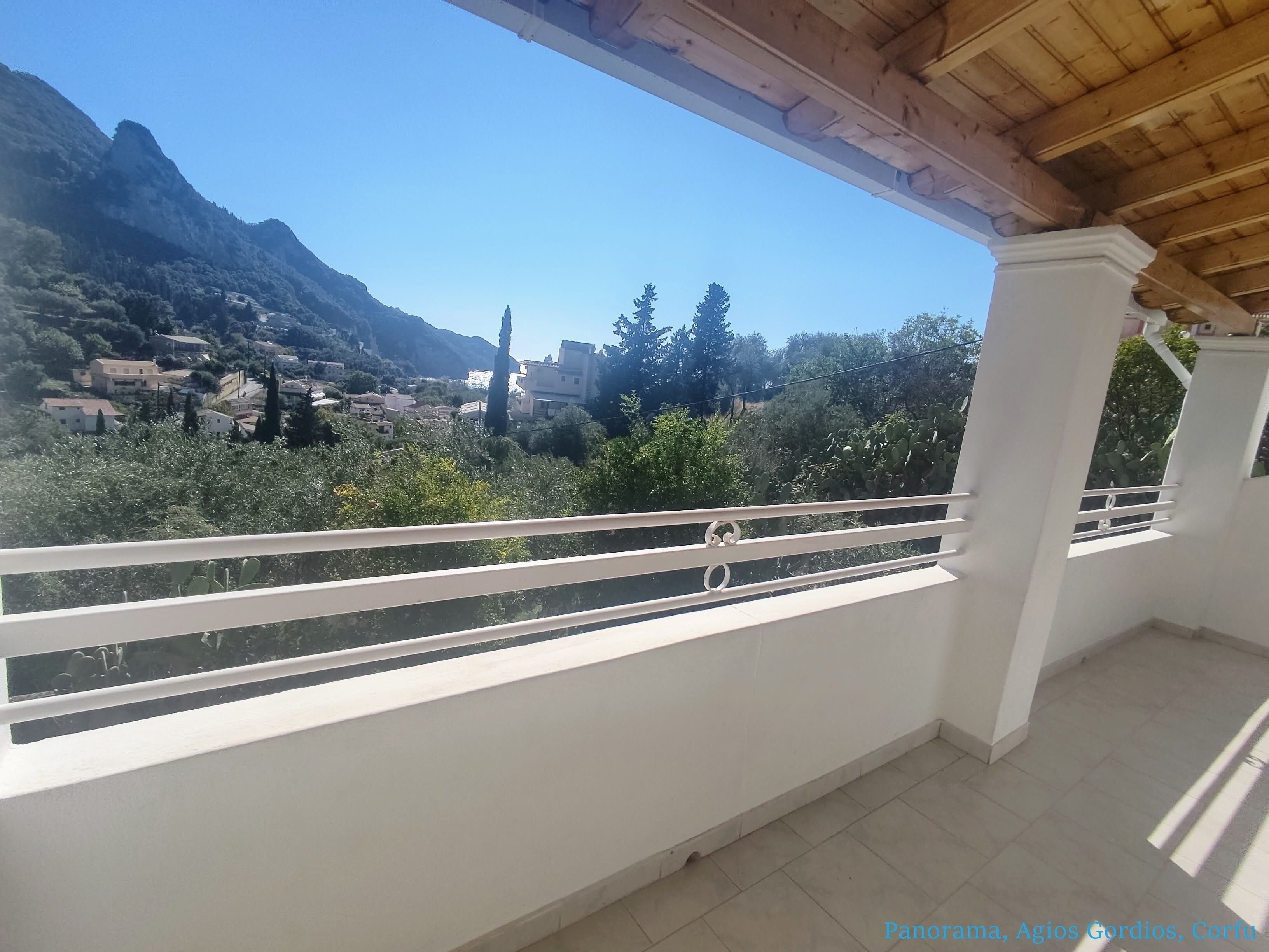 Un balcone con vista su un paesaggio montuoso e edifici.
