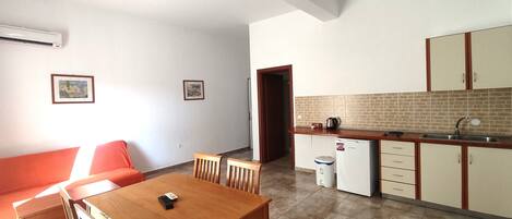 A compact living space with a dining area, kitchenette, and a small seating area.