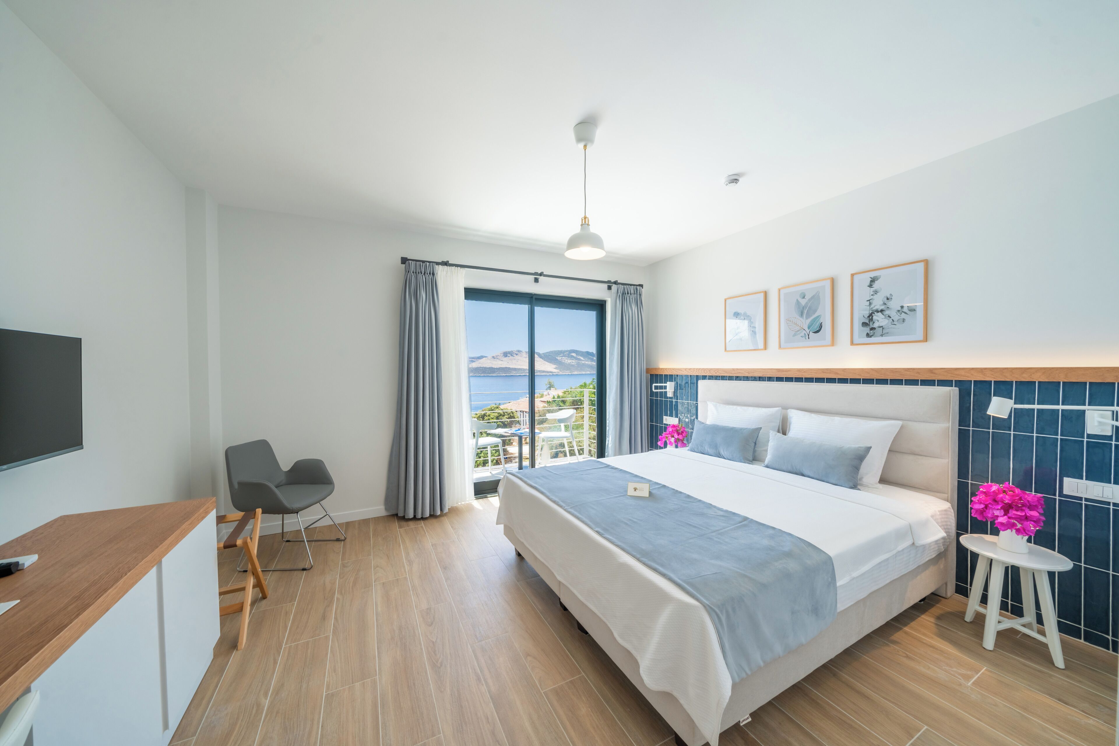 Une chambre d’hôtel moderne avec un grand lit, un bureau et une vue sur la mer.