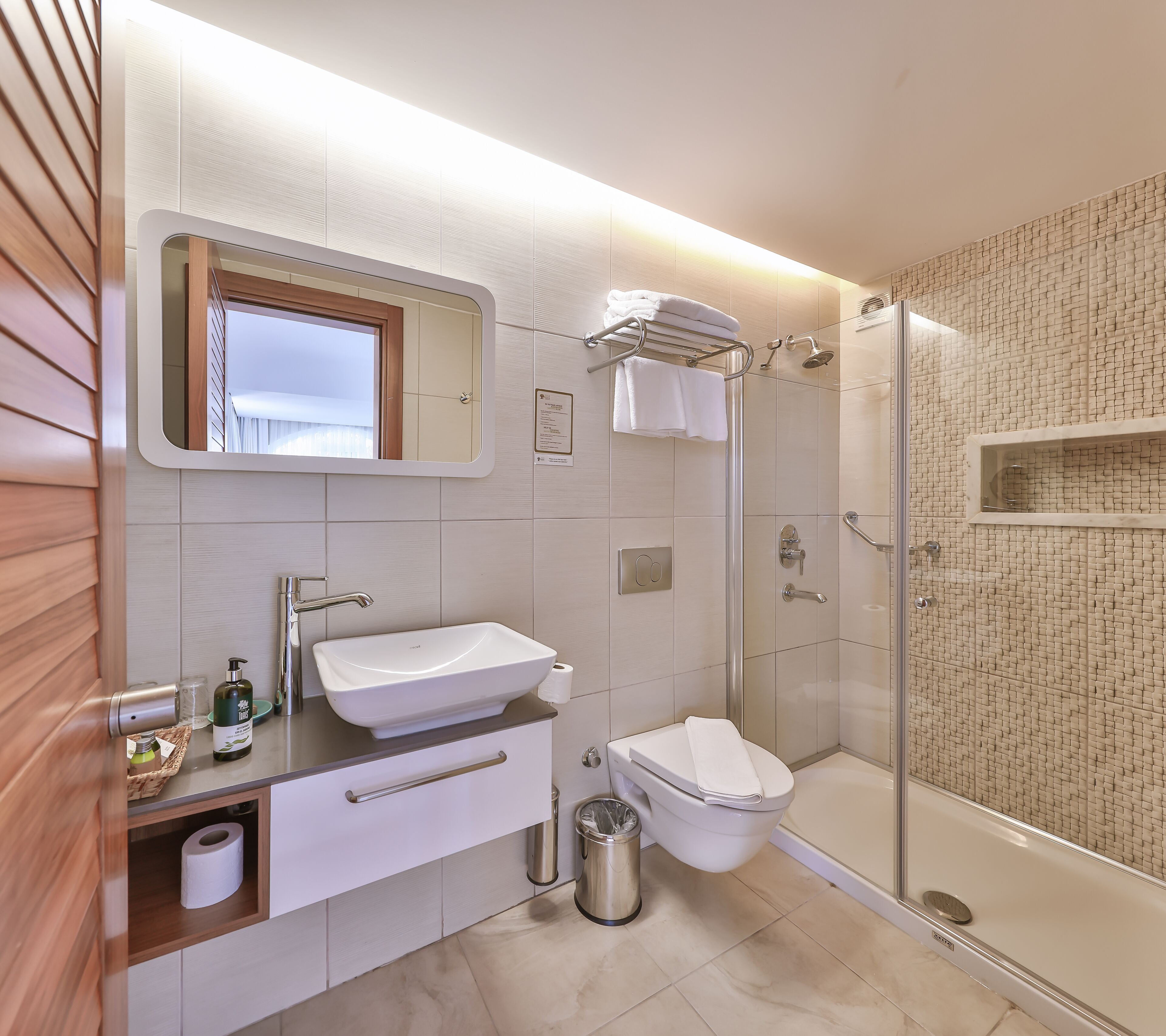 A modern bathroom with a sink, toilet, and shower.