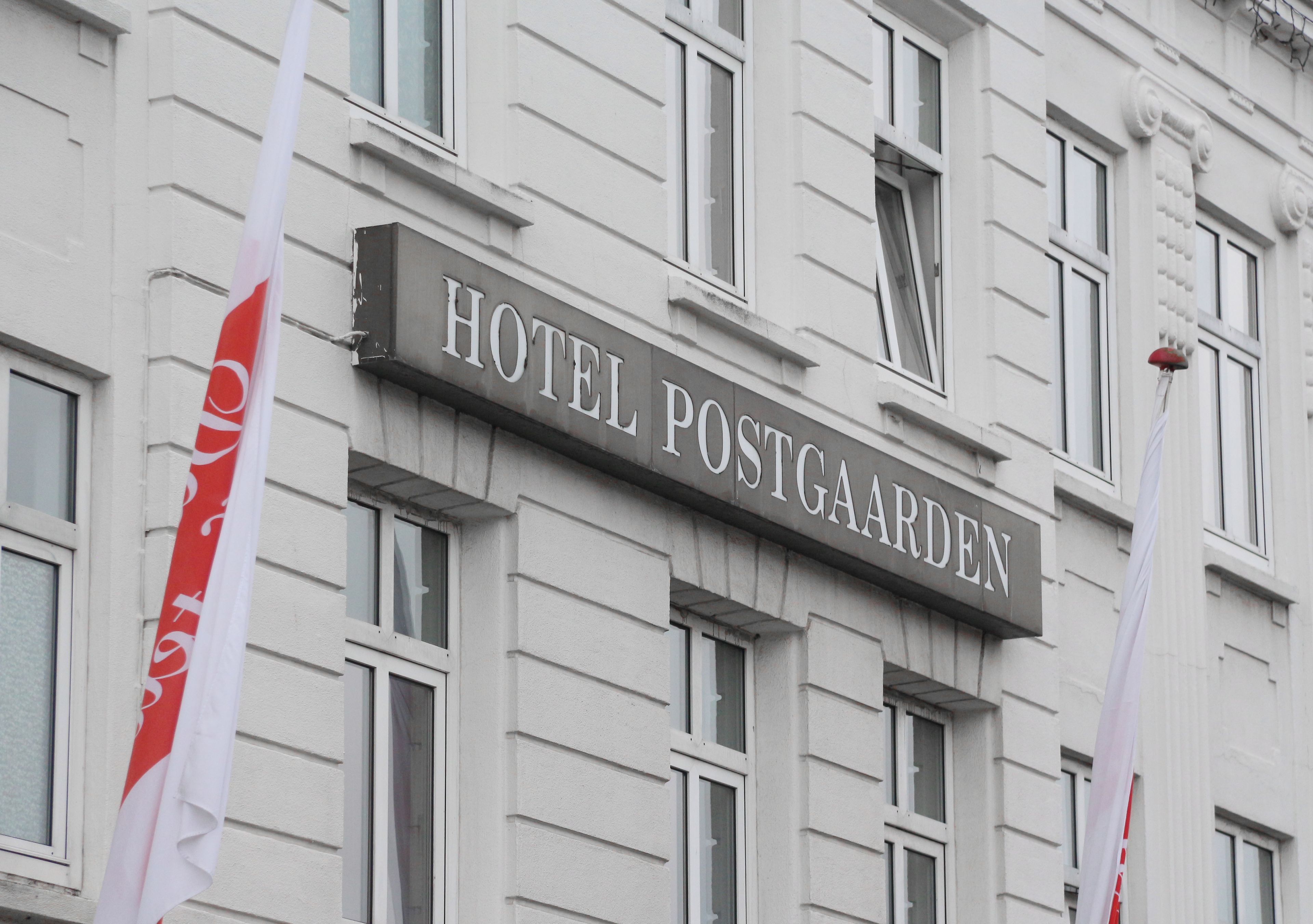A building with a sign that reads 'HOTEL POSTGAARDEN.'