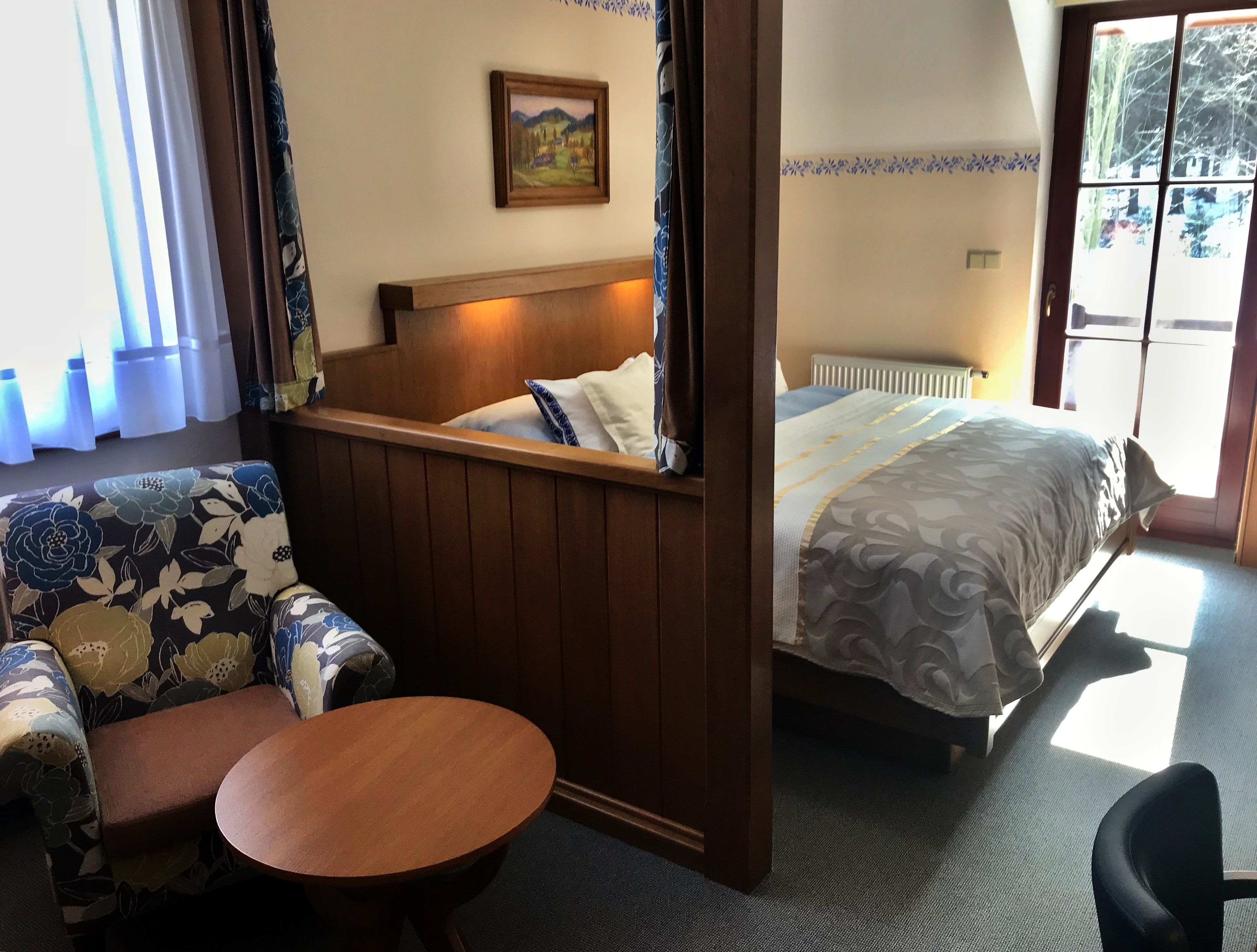 Ein Hotelzimmer mit Bett, einer Couch, einem kleinen Tisch und einem Bild an der Wand.