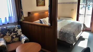 Ein Hotelzimmer mit Bett, einer Couch, einem kleinen Tisch und einem Bild an der Wand.
