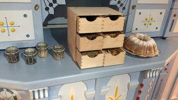 A kitchen counter with a wooden cabinet, jars, and a bundt cake.