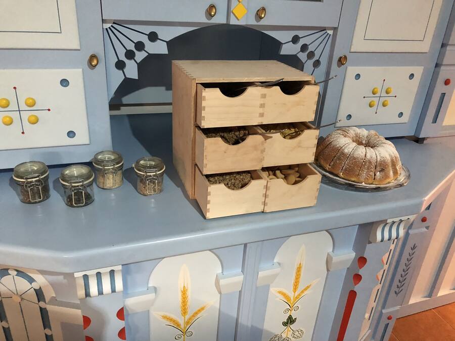 A kitchen counter with a wooden cabinet, jars, and a bundt cake.