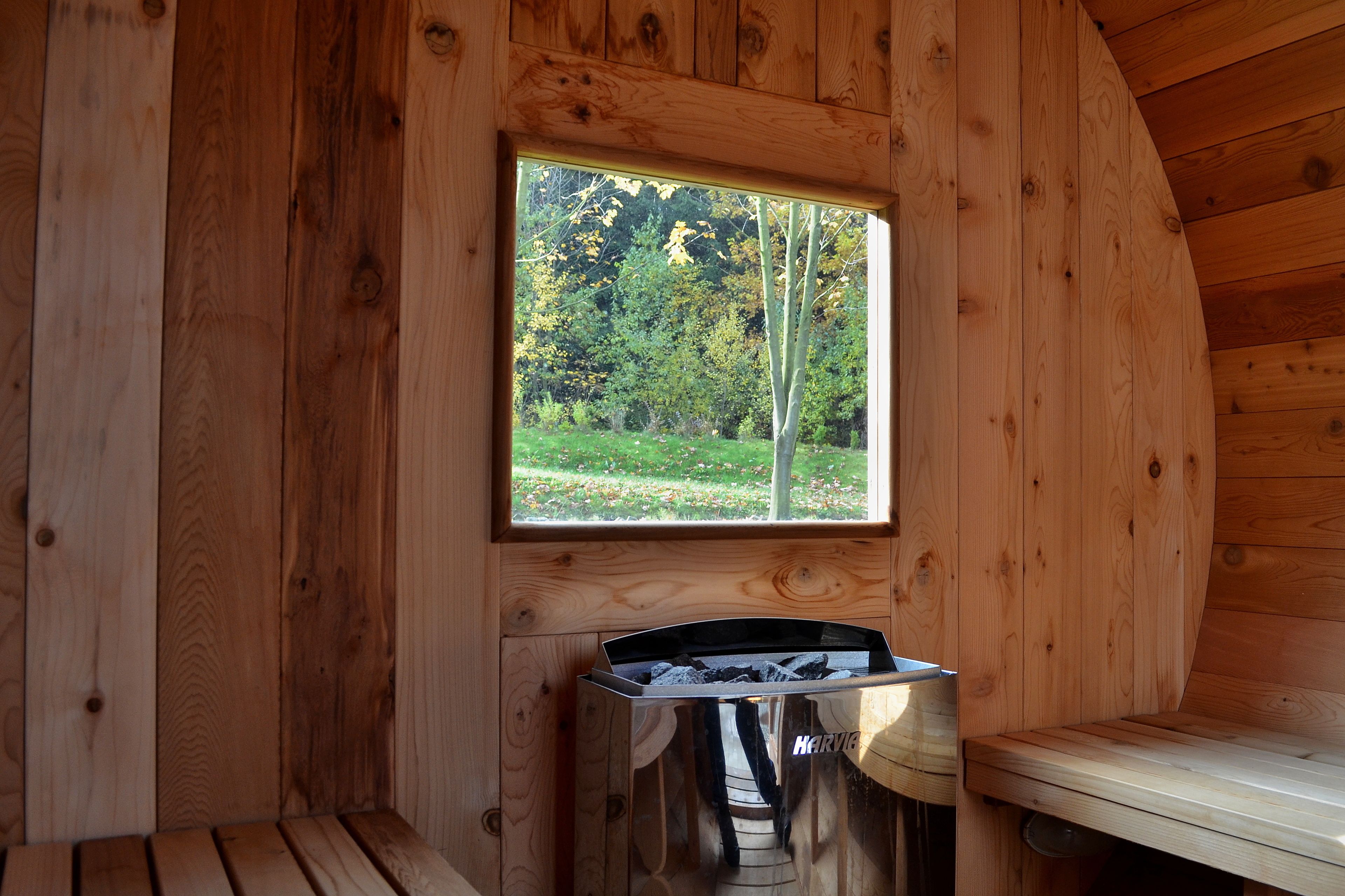 Uma cabana de madeira com janela voltada para uma floresta.