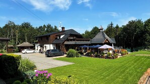 A large, rustic lodge with multiple buildings, a well-maintained lawn, and outdoor seating areas. - Hotel na Dolině (Trojanovice)