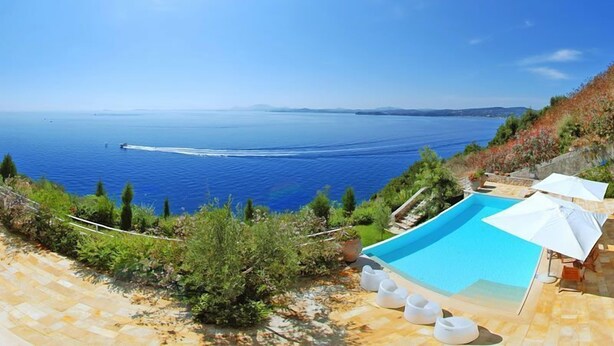 A pool with a view of the sea, surrounded by greenery and a clear sky. - Corfu Luxury Villas (Corfu)