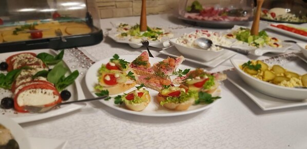 Un bufé con diversos platos, incluyendo ensaladas, aperitivos y postres.