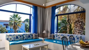 A room with a sofa set, a table, and a dining table with fruit. - Govino Bay (Corfu)