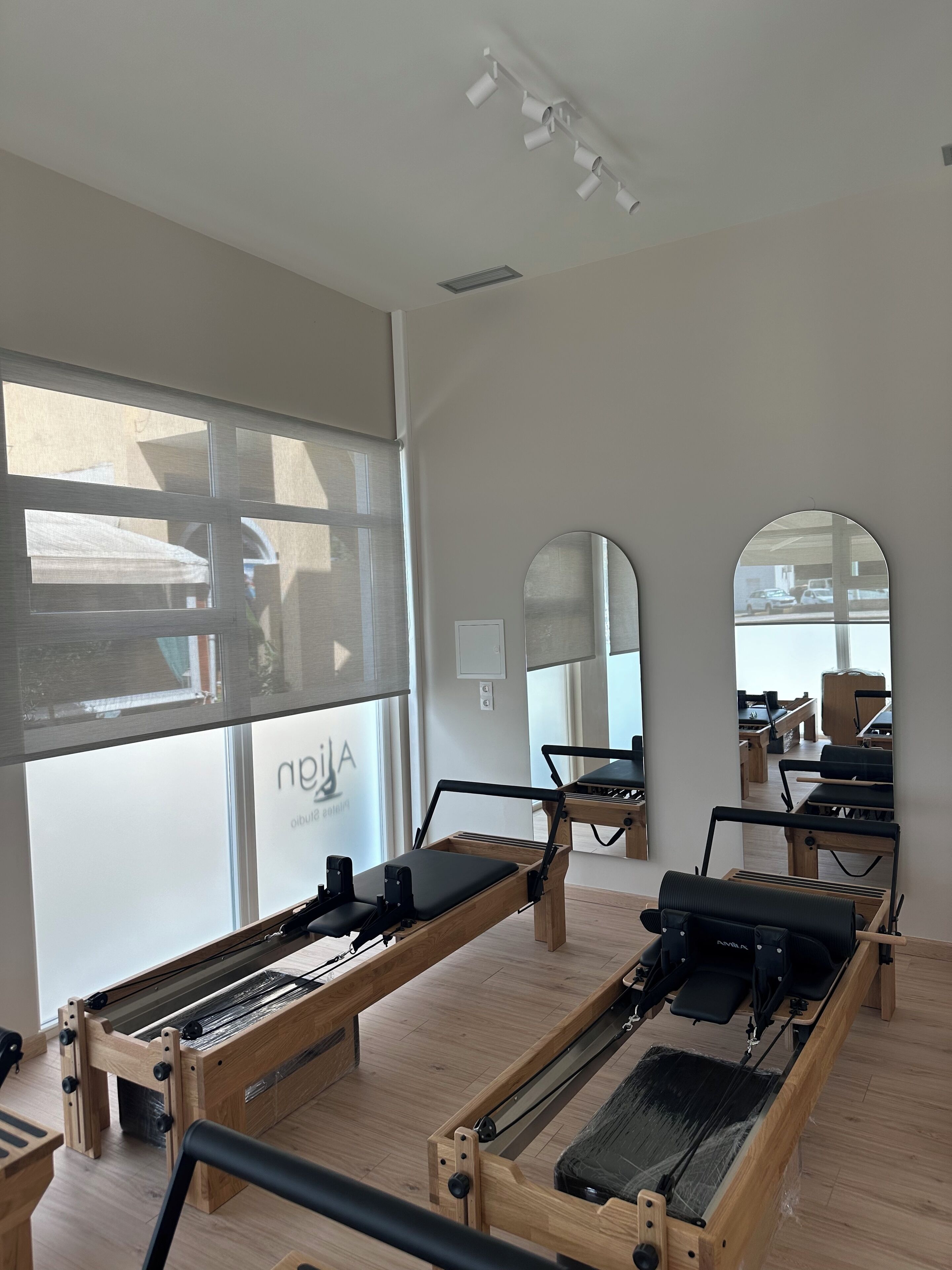 Ein Pilates-Studio mit Holzgeräten und großen Fenstern.