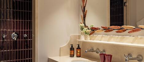 Un baño moderno con un espejo grande, una bañera y un lavamanos.