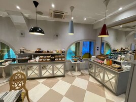 Una cocina moderna con piso a cuadros, una isla central con alimentos y lámparas colgantes.