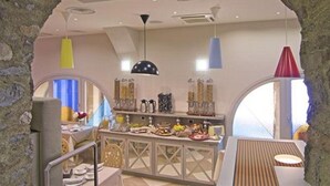 Un comedor con un arco de piedra, una mesa de madera y lámparas colgantes.