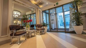 Un vestíbulo con mostrador de recepción, zona de estar y amplias ventanas.