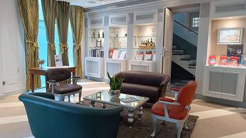 A modern living room with a sofa, chairs, a coffee table, and a bookshelf.